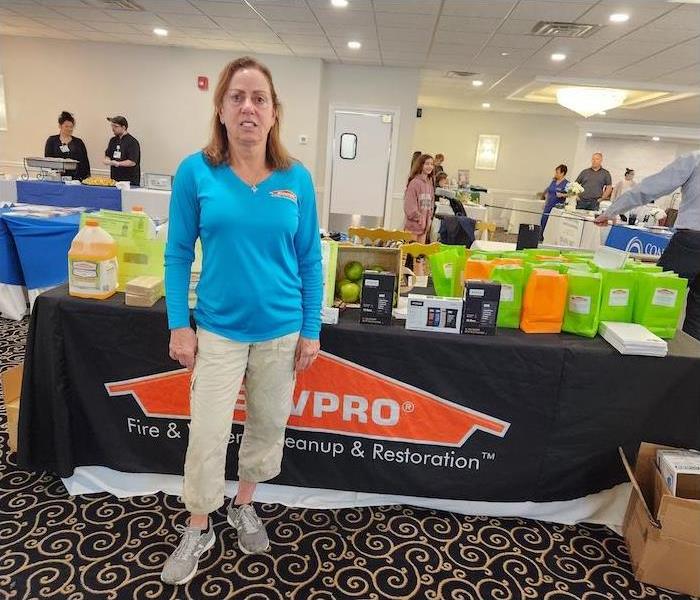 female employee standing in front of a SERVPRO table