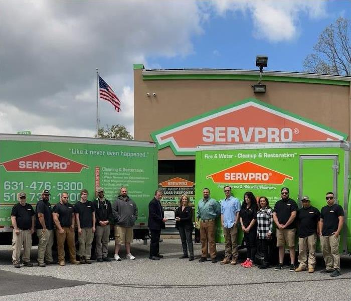 SERVPRO crew standing in front of their vans and building